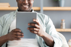 Man in waiting area reading Lifeline on a tablet device