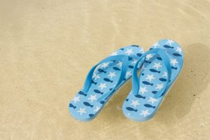 Flip-flops floating in shallow water at the beach.