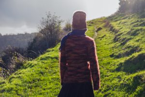 Young woman walking on a hillside.