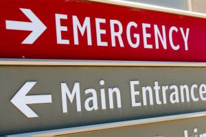 Hospital signs pointing to emergency and main entrances