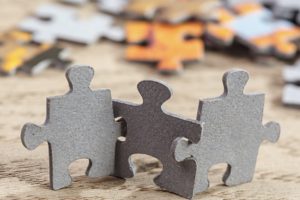 Puzzle pieces standing and “joined arm in arm” like people